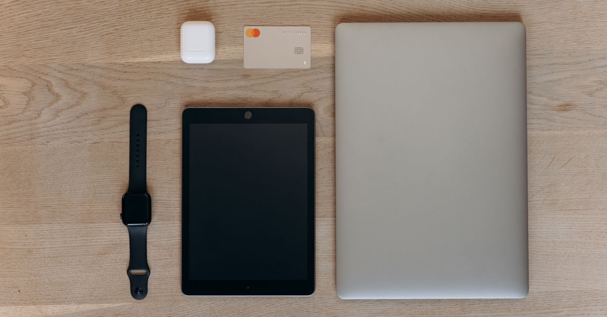 Stylish arrangement of digital devices and accessories on a wooden table, perfect for tech and lifestyle themes.